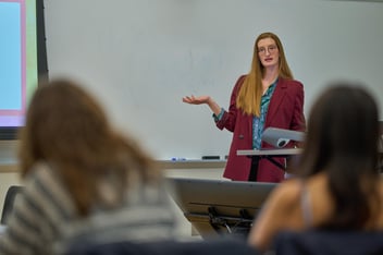 A woman is giving a lecture in a classroom.