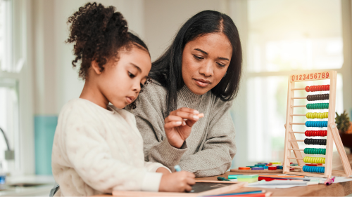 A woman and her daughter are working on a wooden abacus.