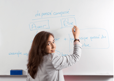 Teacher writing on a white board